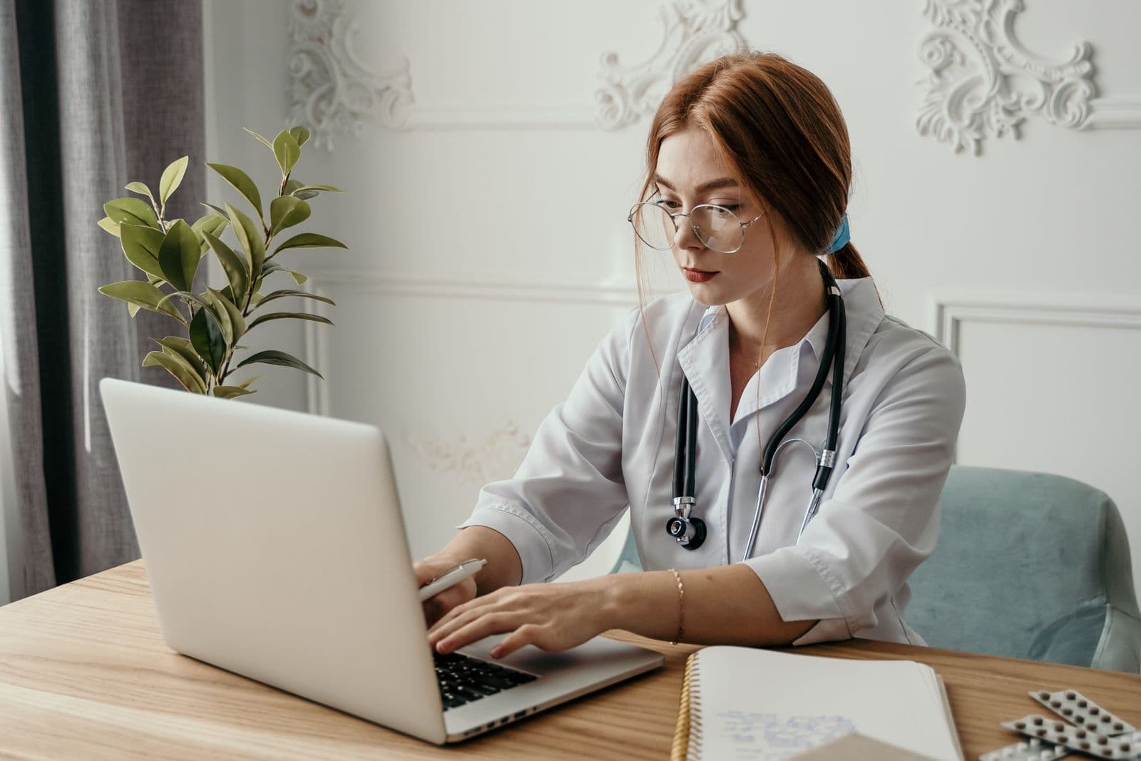 A physician reviewing work on a laptop