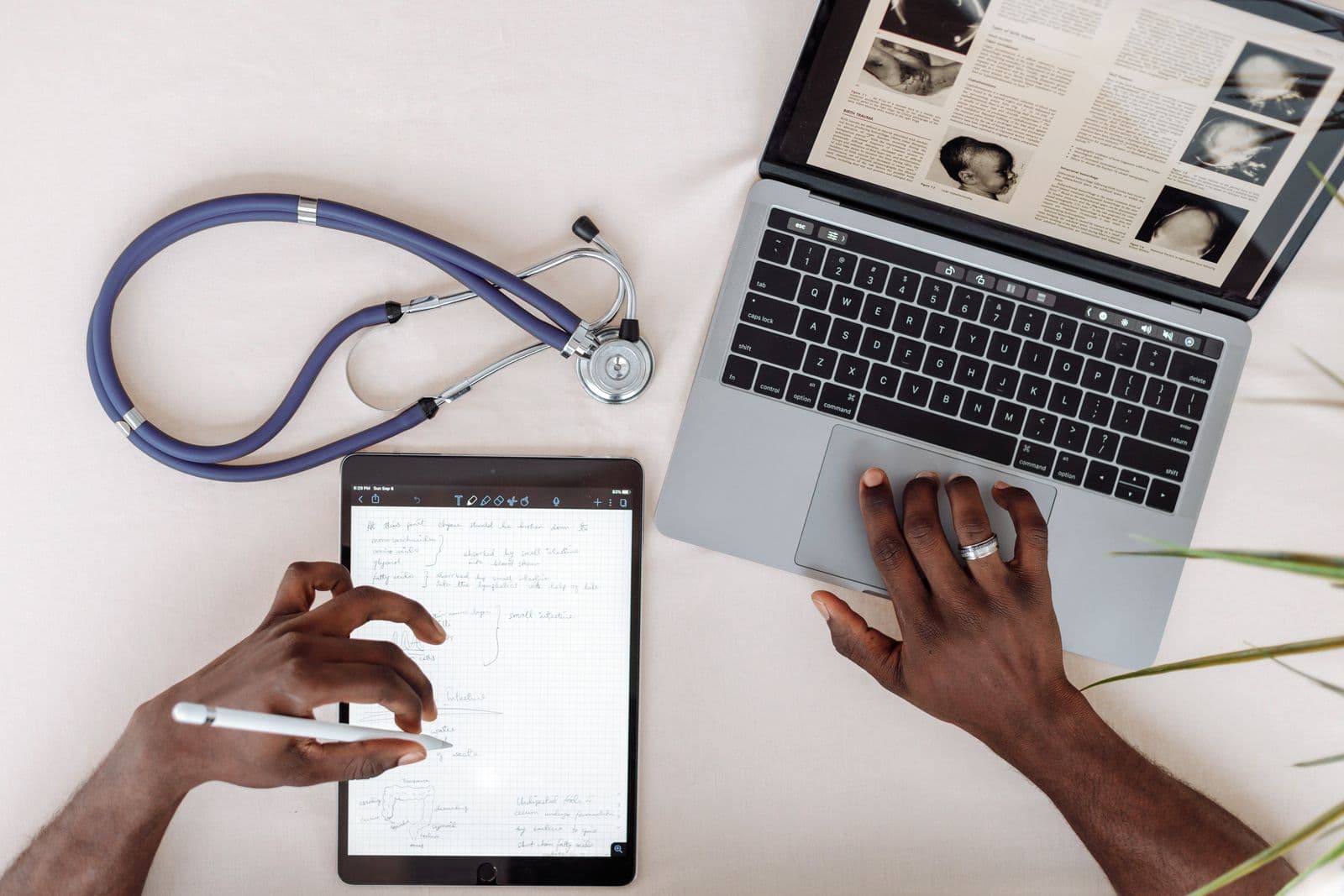 A clinician reviewing documents on a laptop